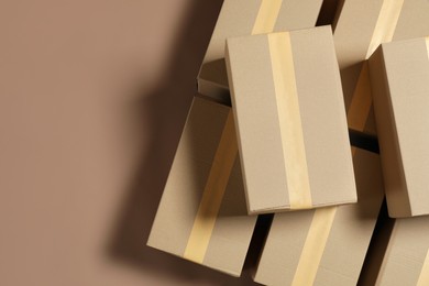 Photo of Many cardboard boxes on light brown background, flat lay. Space for text