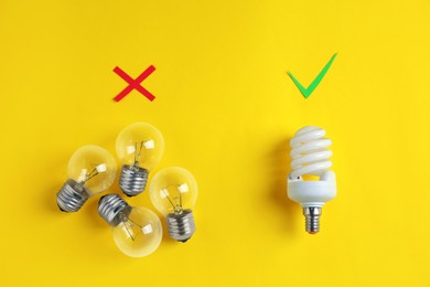 Photo of One fluorescent light bulb and simple ones on yellow background, flat lay. Energy saving concept