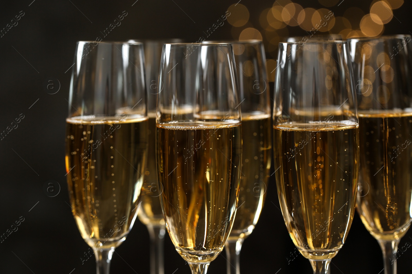 Photo of Many glasses of champagne on blurred background, closeup