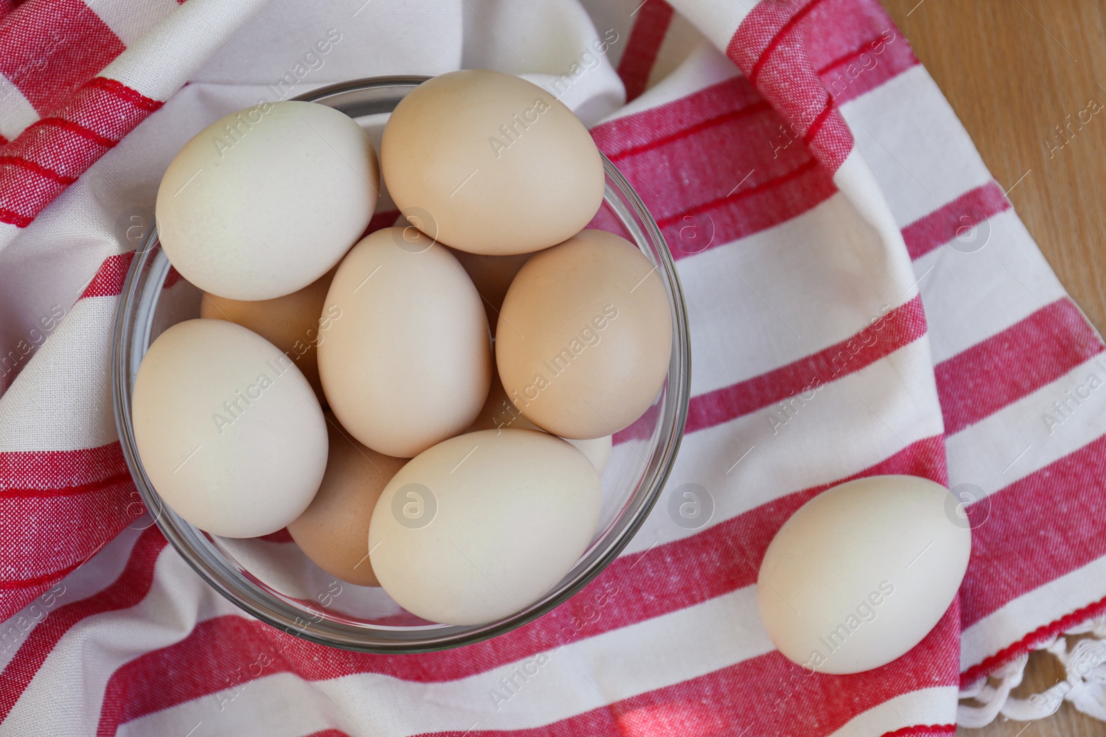 Photo of Fresh raw eggs and towel on table, flat lay