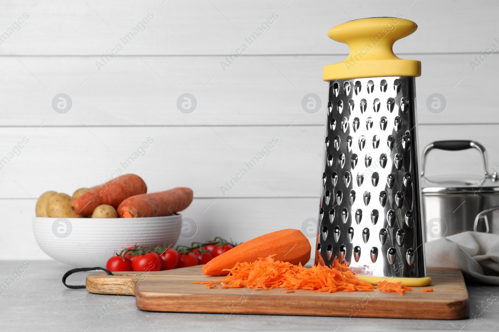 Photo of Grater and fresh ripe vegetables on table