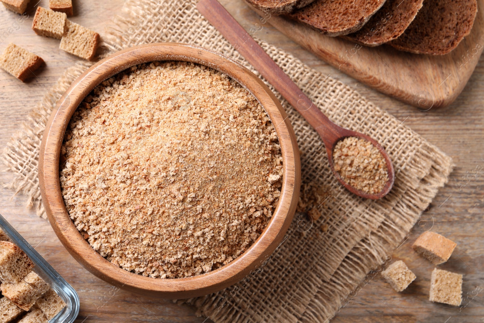 Photo of Fresh breadcrumbs on wooden table, flat lay