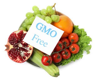 Photo of Fresh fruits, vegetables and card with text GMO Free in bowl on white background, top view