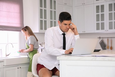 Photo of Man working on laptop in kitchen. Stay at home concept