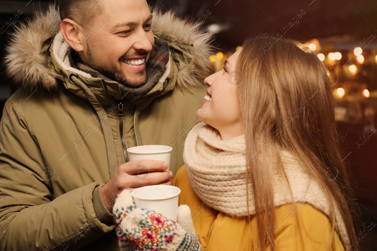 Photo of Happy couple with mulled wine at winter fair