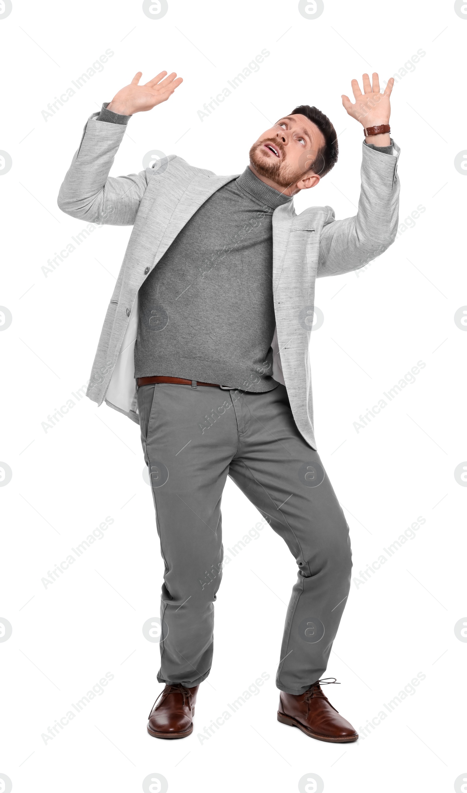 Photo of Emotional bearded businessman in suit evading something on white background