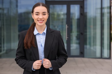 Photo of Happy real estate agent outdoors. Space for text