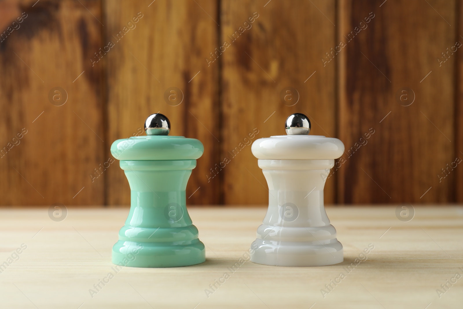 Photo of Salt and pepper shakers on light wooden table