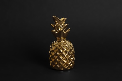 Photo of Gold metal decorative pineapple on black background