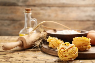 Photo of Raw noodles and ingredients on wooden table, space for text