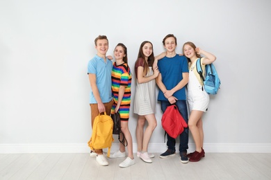 Photo of Group of teenagers against light wall. Youth lifestyle and friendship