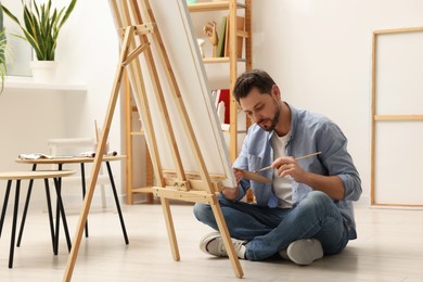 Photo of Handsome man painting in studio. Creative hobby