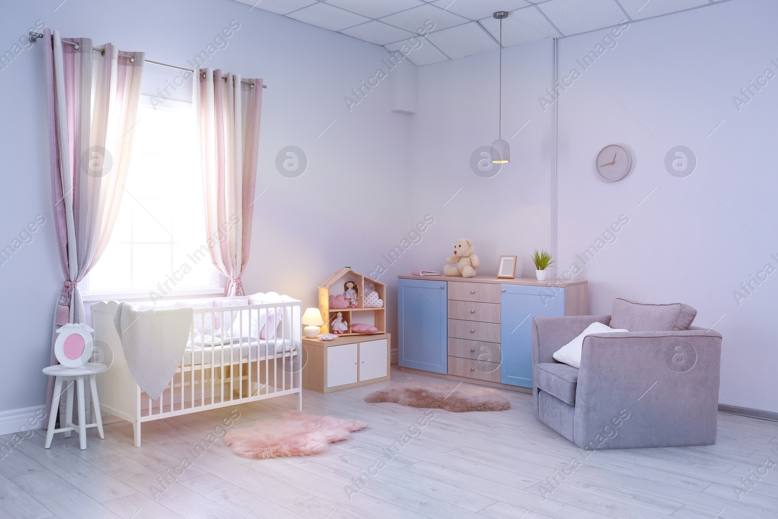 Photo of Baby room interior with comfortable crib and armchair