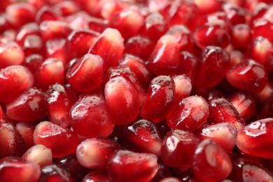 Photo of Ripe juicy pomegranate grains with water drops as background, closeup