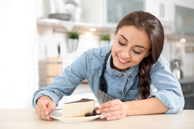Photo of Professional female chef presenting dessert on table in kitchen
