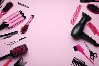 Photo of Flat lay composition with modern hair dryer and triple curling iron on pink background, space for text