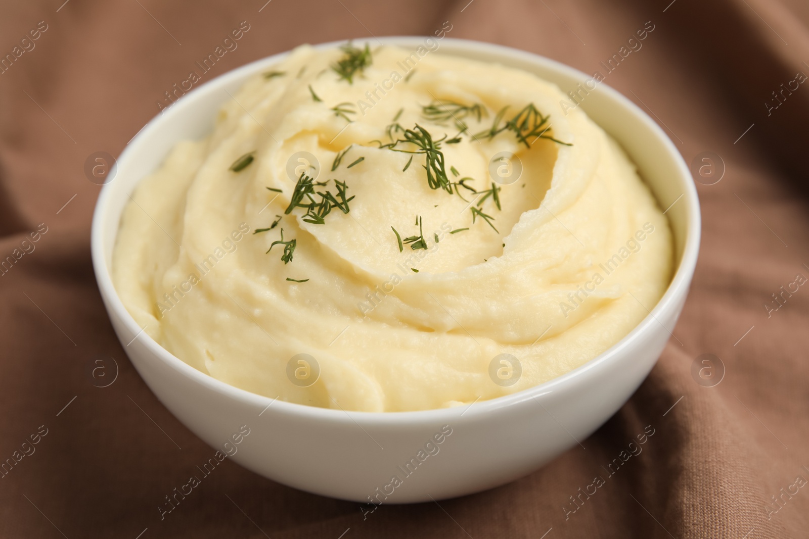 Photo of Freshly cooked homemade mashed potatoes on brown fabric