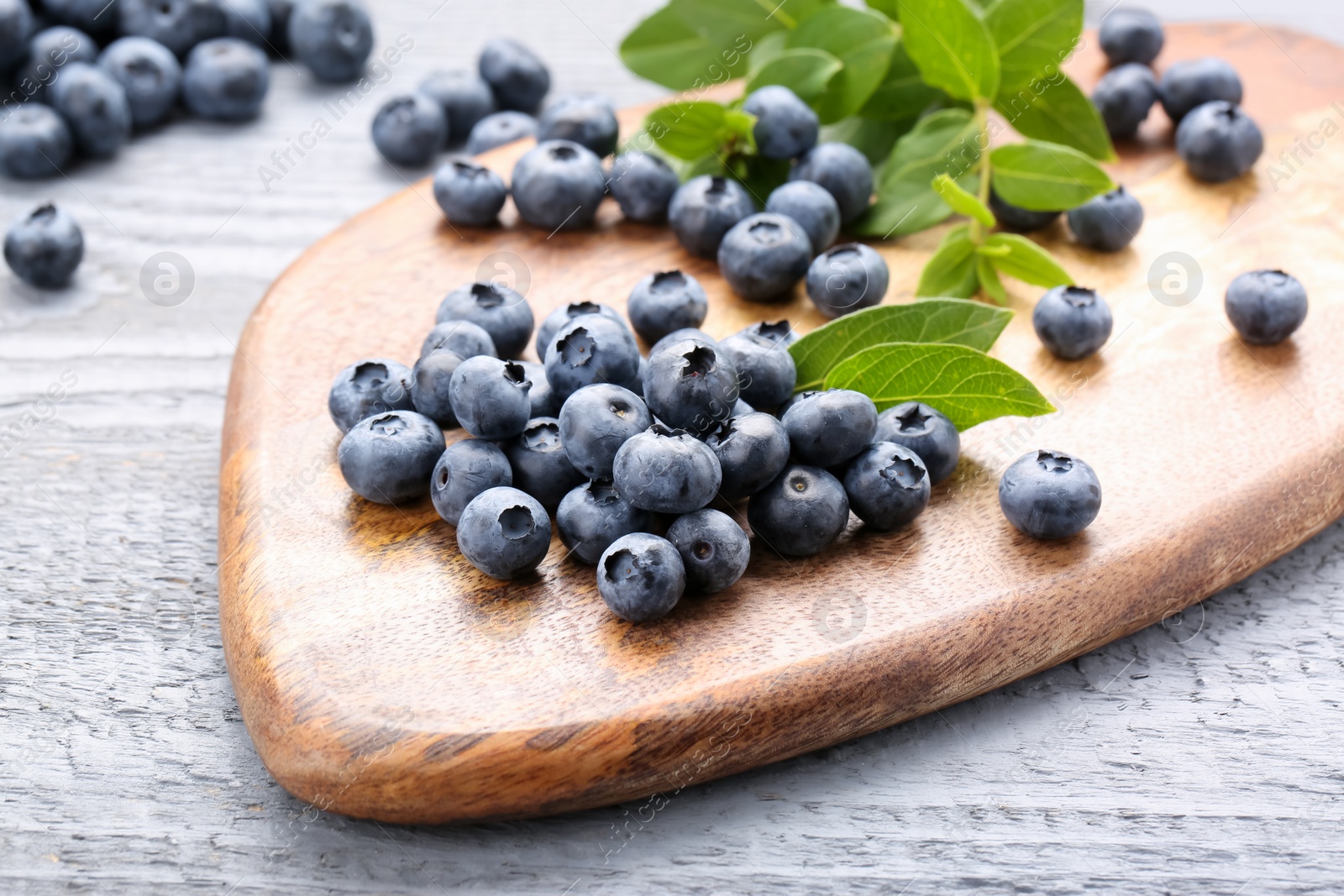 Photo of Tasty fresh blueberries on wooden table, closeup