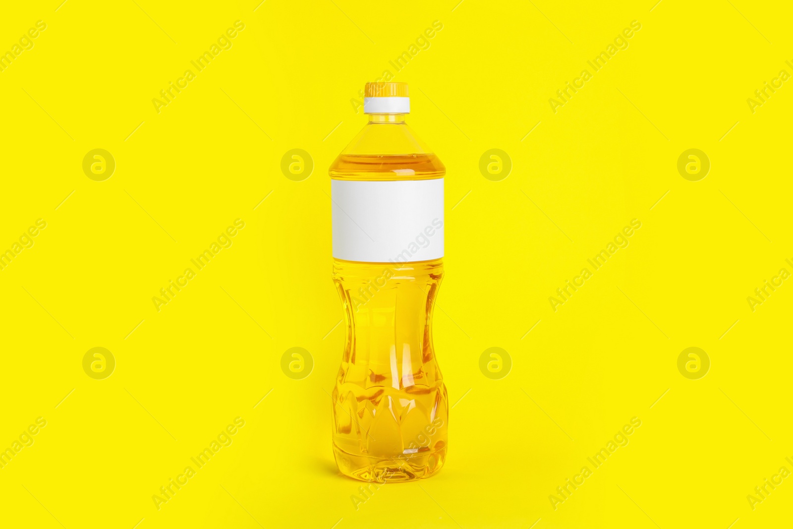 Photo of Bottle of cooking oil on yellow background