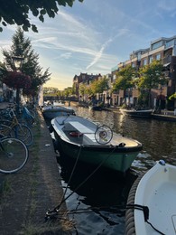 Leiden, Netherlands - August 1, 2022: Picturesque view of city canal with moored boats and beautiful buildings