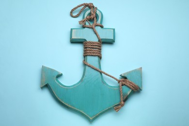 Photo of Wooden anchor figure on light blue background, top view
