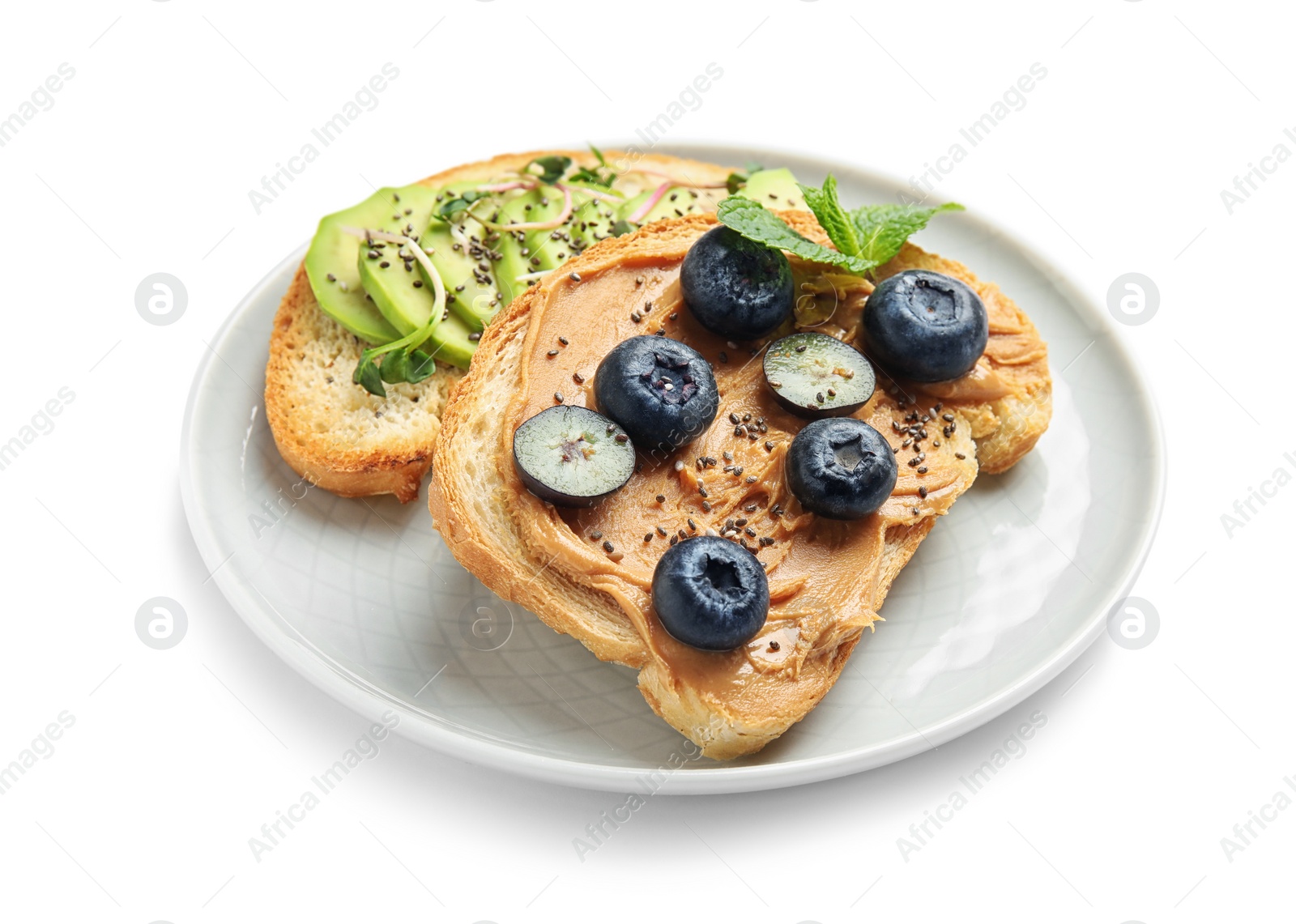 Photo of Plate of tasty toasts with avocado, blueberries and chia seeds on white background