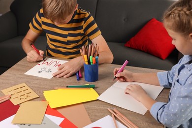 Children making beautiful greeting cards at table indoors