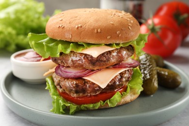 Photo of Tasty hamburger with patty, cheese and vegetables served on table, closeup