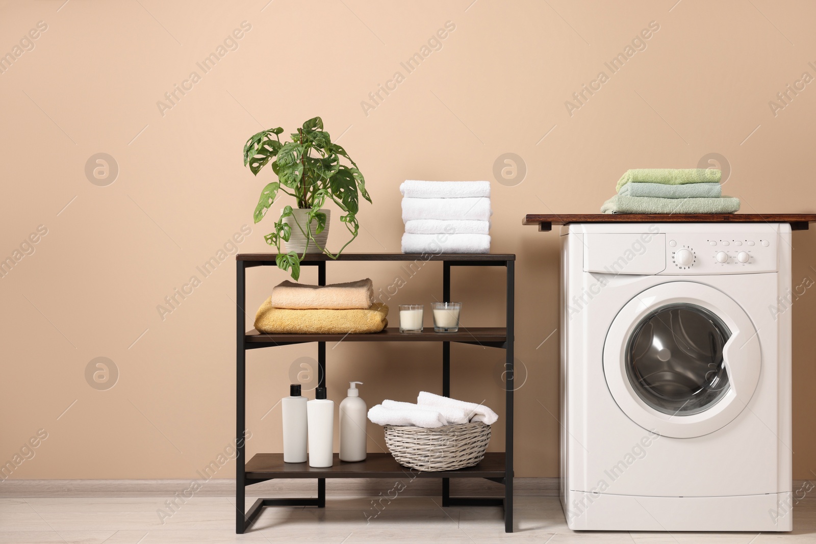 Photo of Stylish laundry room with modern washing machine. Interior design