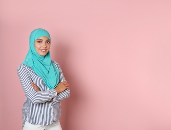 Portrait of young Muslim woman in hijab against color background. Space for text