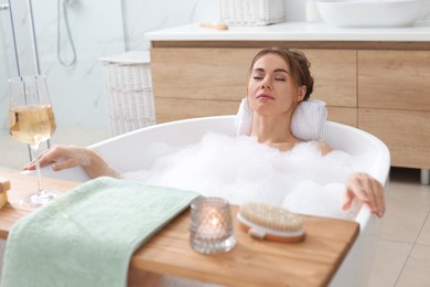 Photo of Beautiful woman enjoying bubble bath at home