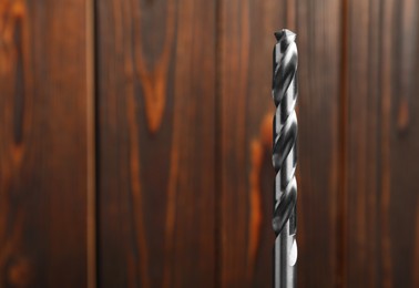 Closeup view of drill bit on wooden background. Space for text