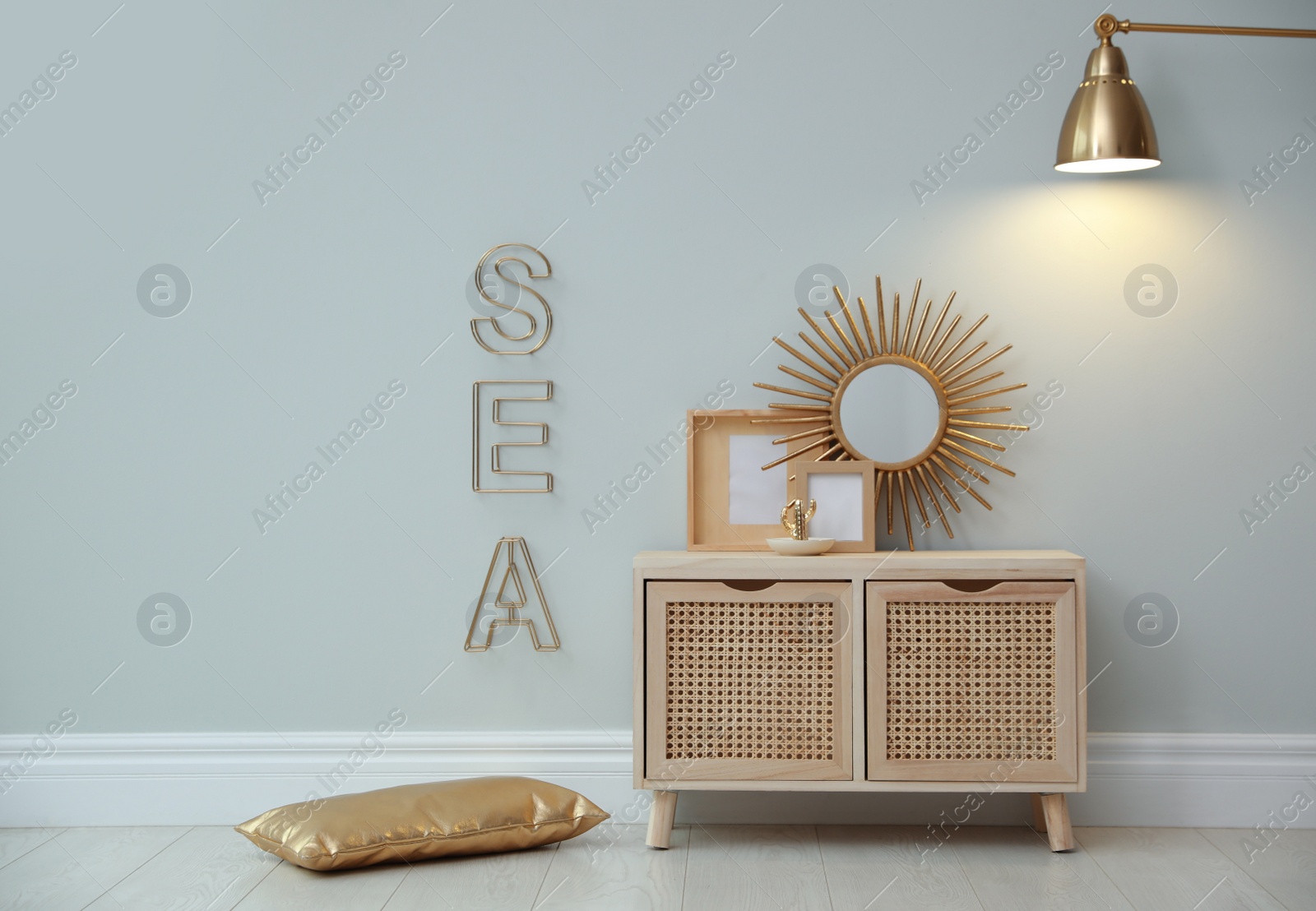 Photo of Stylish room interior with wooden cabinet near grey wall