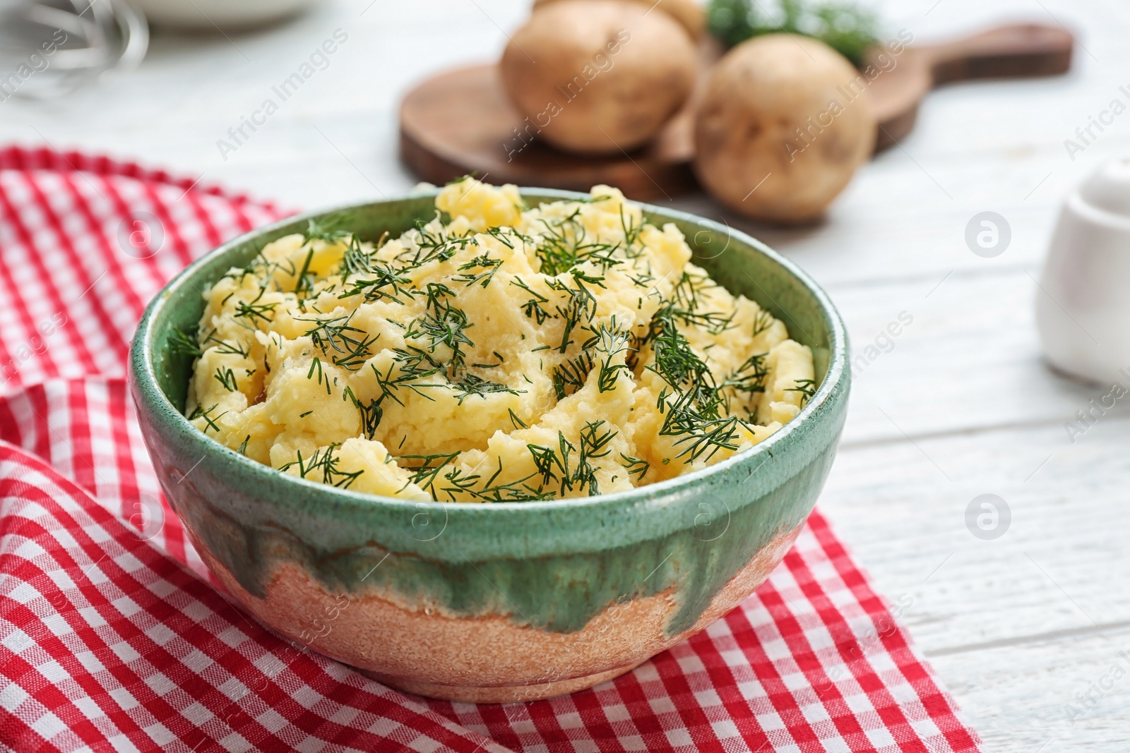 Photo of Bowl with tasty mashed potatoes on table