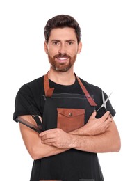 Smiling hairdresser holding combs and scissors on white background