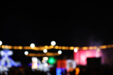 Photo of Blurred view of city street with festive lights at night. Bokeh effect