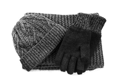 Black woolen gloves, scarf and hat on white background, top view. Winter clothes