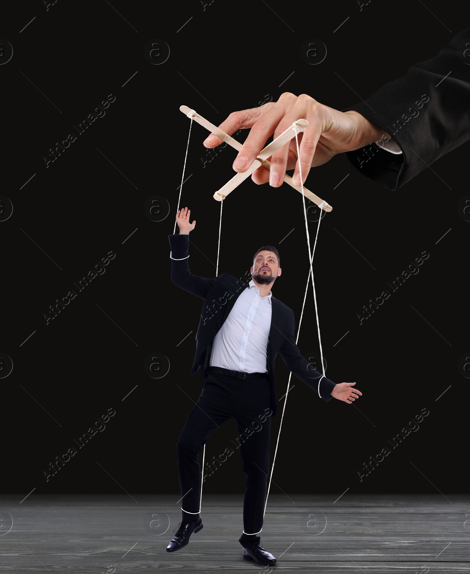 Image of Human relationships demonstrated in puppet show. Worker manipulated by director or manager on black background