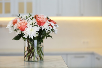 Photo of Vase with beautiful flowers on table in kitchen, space for text. Interior design