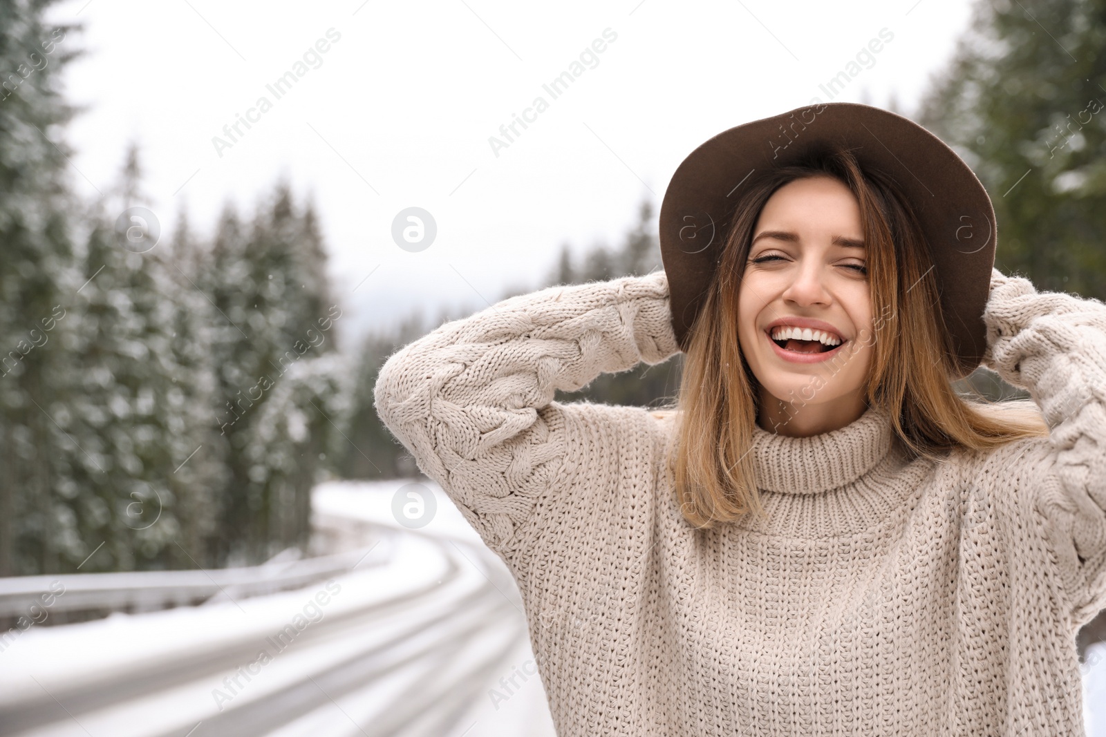 Photo of Young woman in warm sweater outdoors. Winter vacation