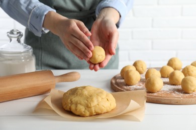 Photo of Shortcrust pastry. Woman making dough ball at white wooden table, closeup