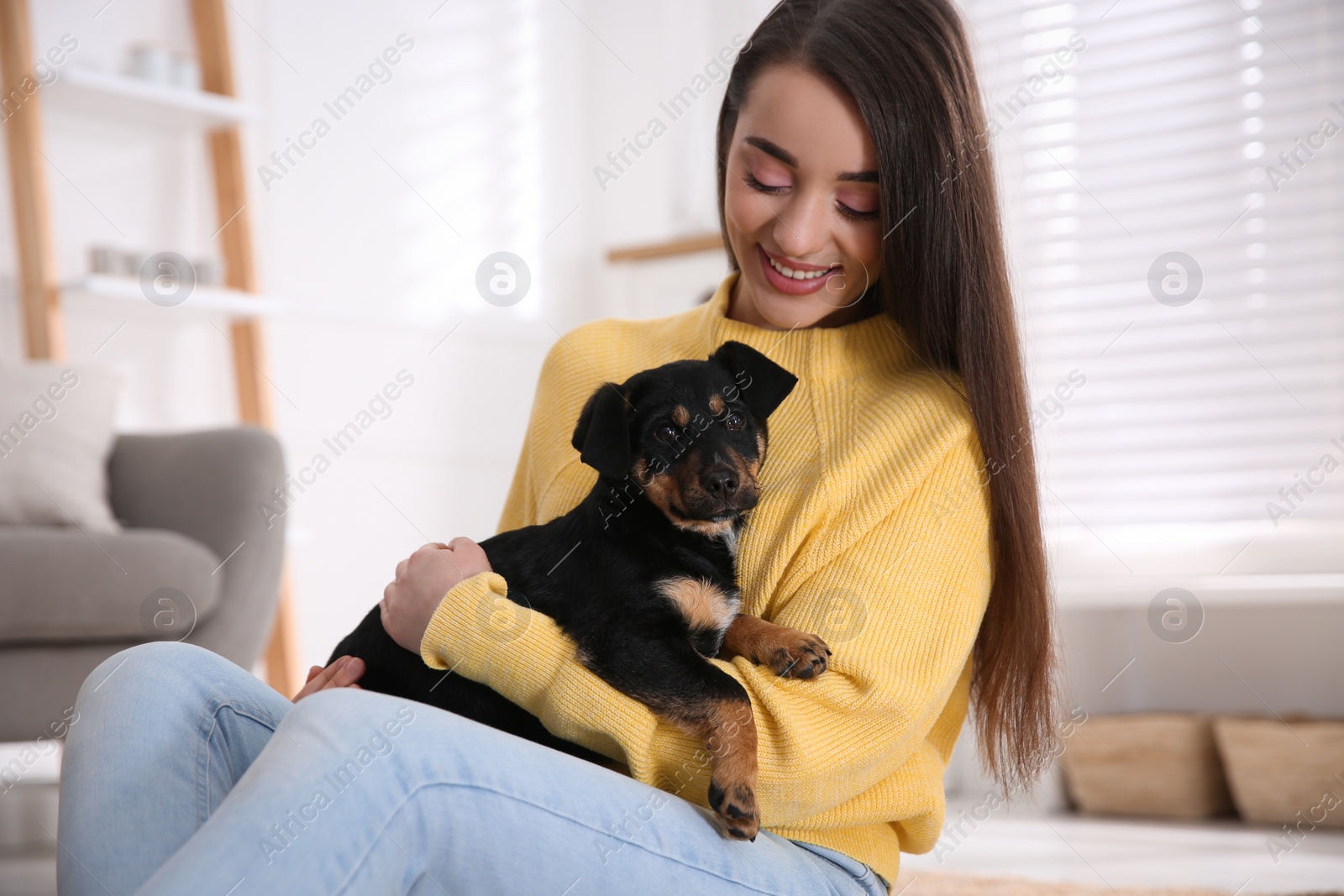 Photo of Woman with cute puppy indoors. Lovely pet