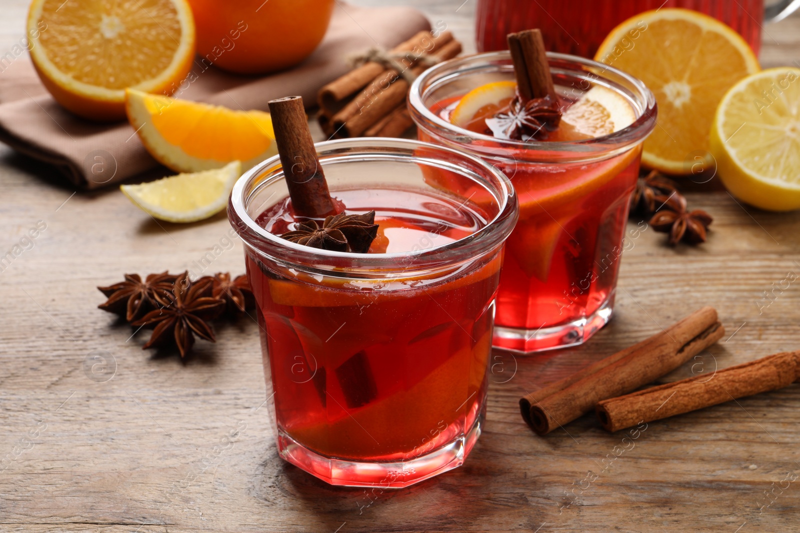 Photo of Aromatic punch drink and ingredients on wooden table