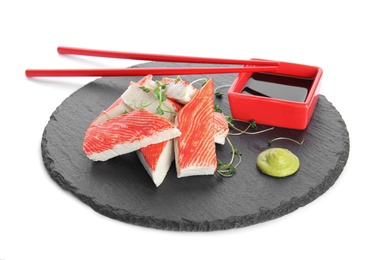 Photo of Slate plate with fresh crab sticks and soy sauce on white background