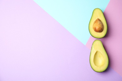 Cut fresh ripe avocado on color background, flat lay with space for text