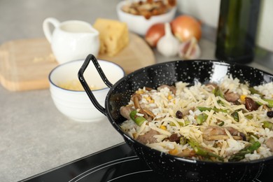 Photo of Delicious risotto in pan on stove, closeup