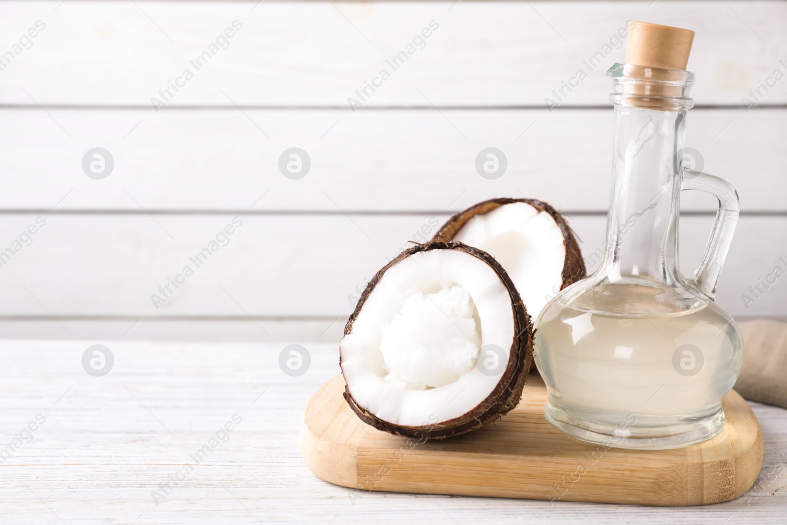 Photo of Coconut oil on white wooden table. Space for text