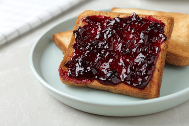 Photo of Delicious crispy toasts with jam on table, closeup