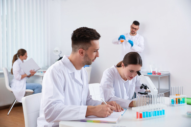 Photo of Medical students with microscope in modern laboratory