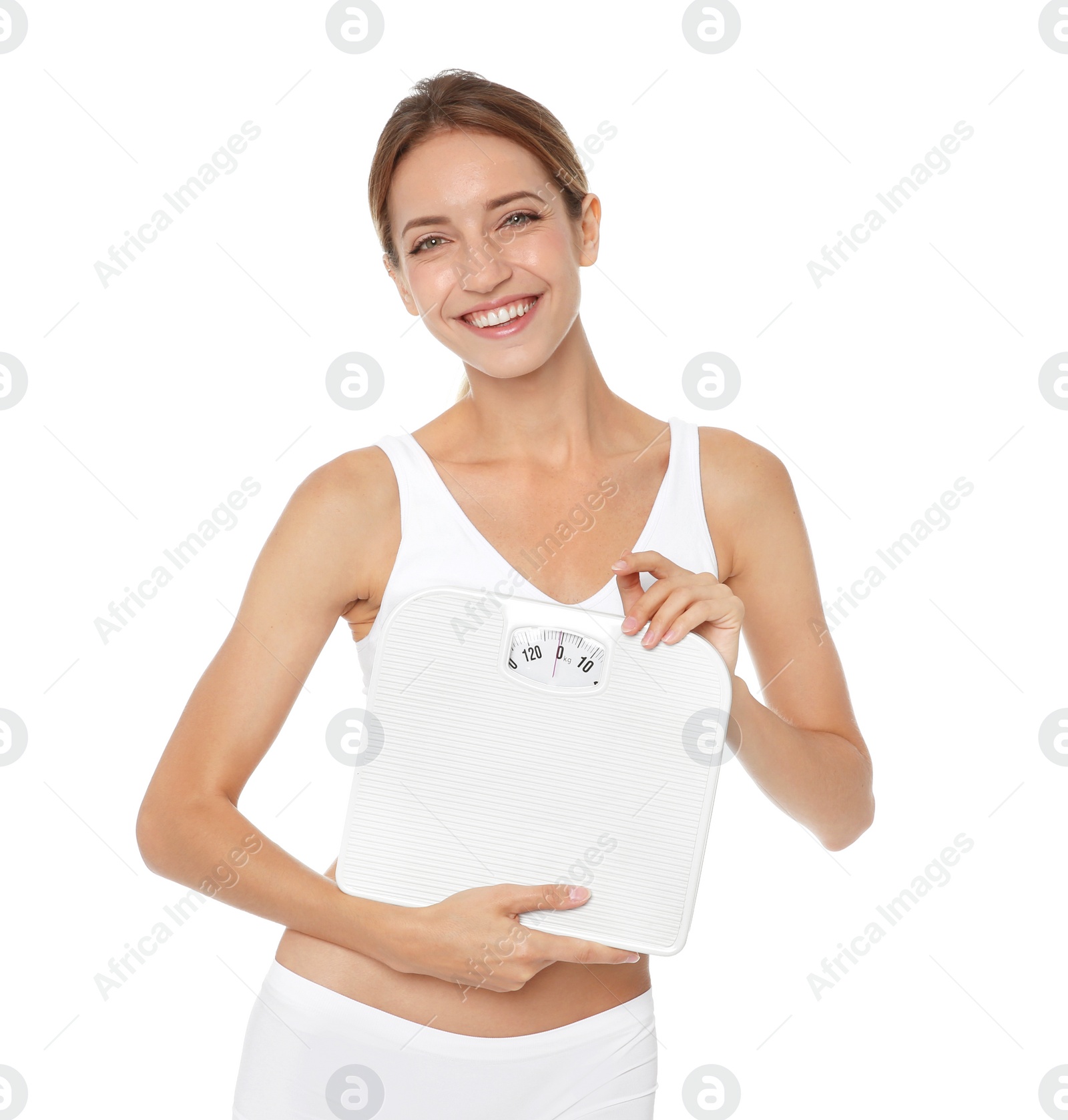 Photo of Happy slim woman satisfied with her diet results holding bathroom scales on white background